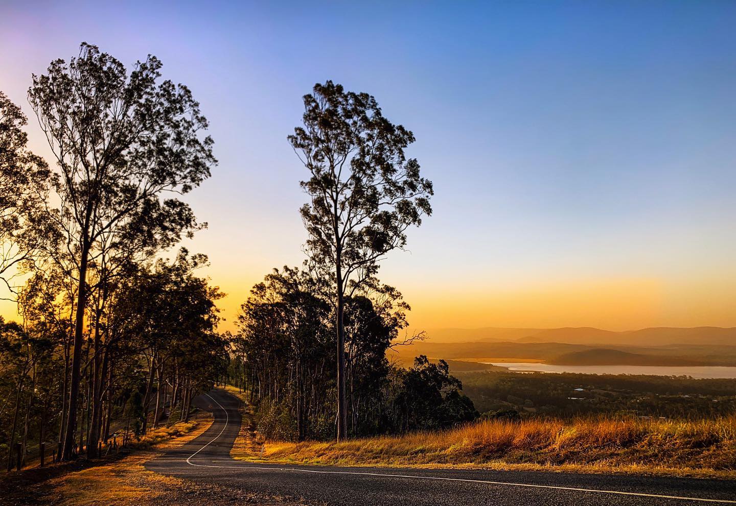 A winding road through the Samford Valley at sunrise, near Camp Mountain